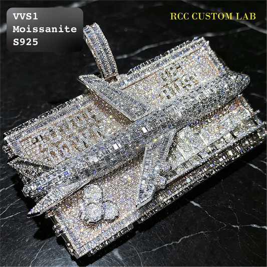 A heavily embellished rectangular pendant or tray covered in clear stones, photographed on a dark marble surface. The text overlays read 'VVS1 Moissanite S925' and 'RCC CUSTOM LAB'; the product itself appears silver-toned with clear gemstones.