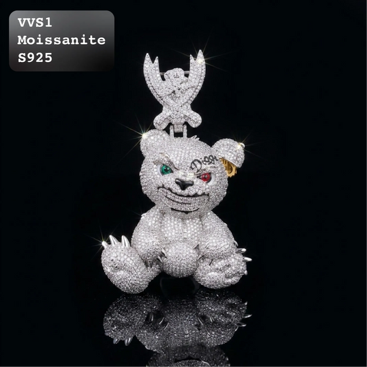 A moissanite-covered bear pendant with an evil grin and mismatched colored eyes, featuring a small moissanite angel on top, set against a black background with a reflection below.