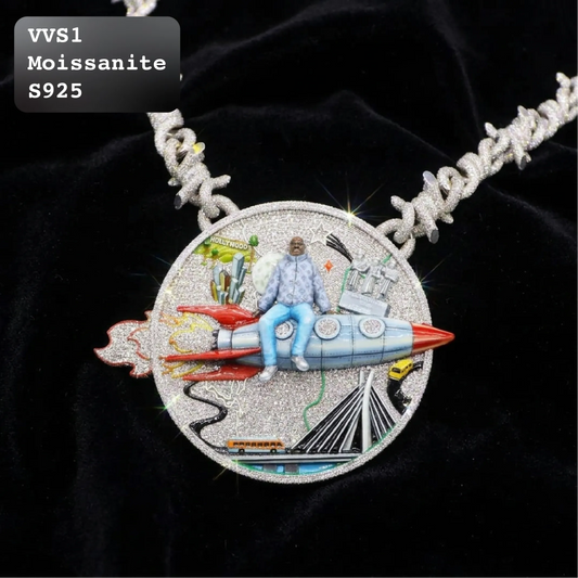A highly detailed, round pavé necklace featuring a silver-toned medallion with a 3D rocket ship, a seated figure in a light blue jacket and jeans, and a cityscape. The pendant is displayed on a black velvet background with a silver textured chain.