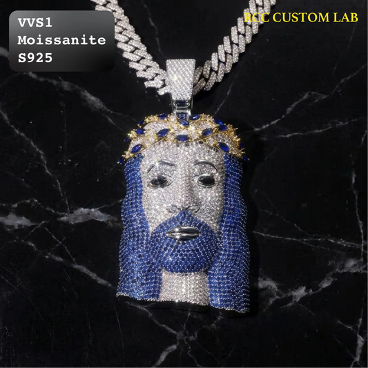 A custom Jesus head pendant necklace encrusted with blue and silver stones, hanging from a silver chain on a black marble background. Text overlays read 'VVS1 Moissanite S925' and 'VVS CUSTOM LAB'.