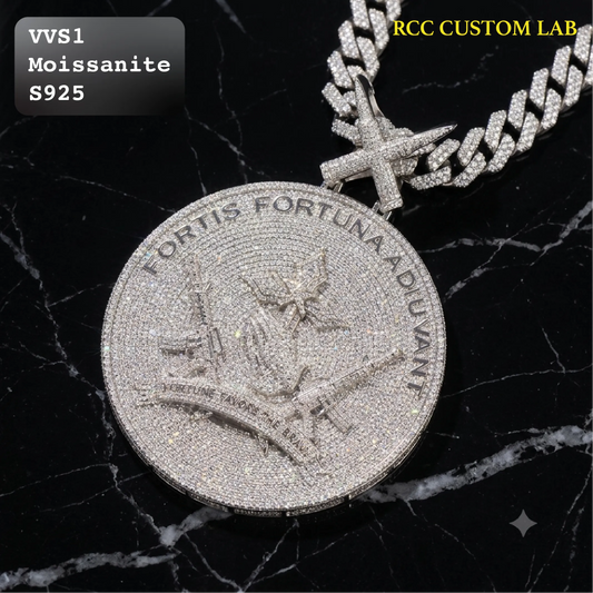 A round, heavily paved silver pendant with a cross bail, displayed on a black marble background. The pendant features an embossed design with the text 'FORTIS FORTUNA ADULANT'.