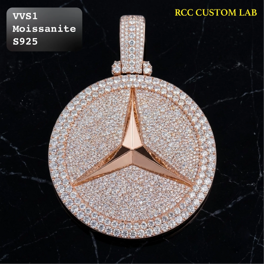 A round rose gold pendant featuring a three-pointed star motif paved with clear stones, set against a black marble background. Text overlays indicate 'VVS1 Moissanite S925' and 'RCC CUSTOM LAB'.