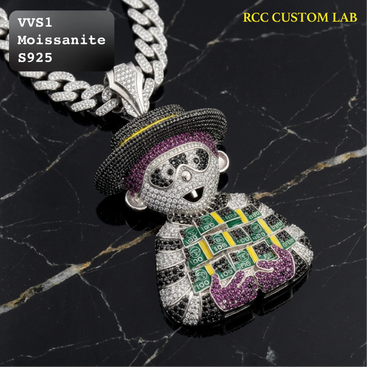 A custom cartoon-style pendant necklace featuring a character encrusted with silver-toned stones, set with purple and yellow enamel details, resting on a black marble background. Text overlays read 'VVS1 Moissanite S925' and 'RCC CUSTOM LAB'.