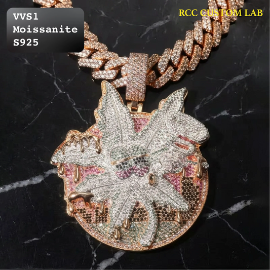 A close-up of a large circular pendant necklace on a matching chain, covered in clear rhinestones and set in a rose-gold-toned metal. The pendant features a stylized leaf or maple leaf motif with snakeskin-textured edges and pink, green, and blue iridescent inlay details.