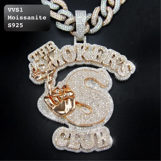 A close-up of a large pendant necklace on a black background. The pendant is heavily embellished with clear rhinestones and features rose gold-toned lettering and details, including the words 'THE SMOKER' and 'CLUB'.