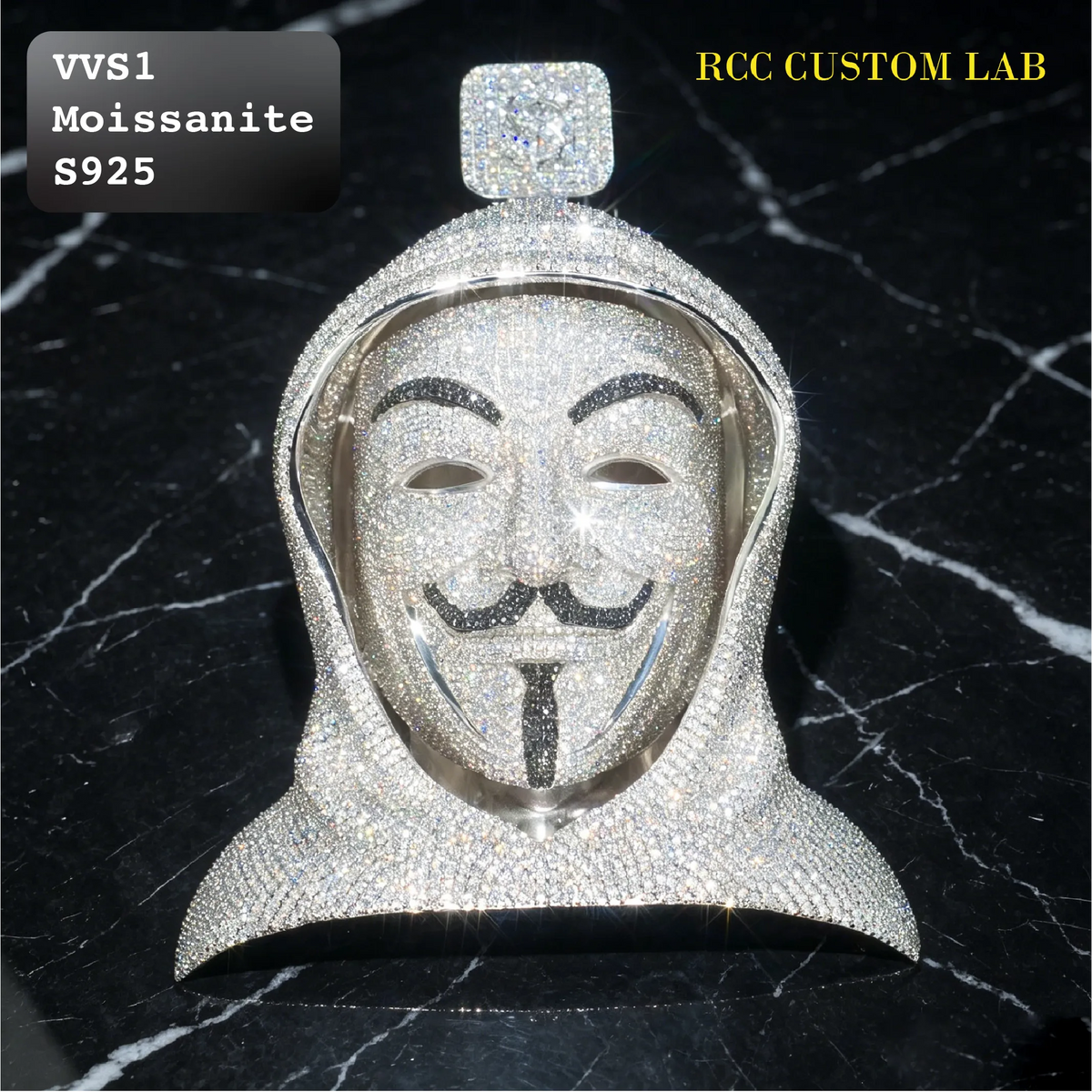 A silver-toned custom pendant shaped like a hooded figure wearing a Guy Fawkes mask, heavily embellished with clear rhinestones. The pendant is displayed on a black marble background with text overlays reading 'VVS1 Moissanite S925' and 'RCC CUSTOM LAB'.