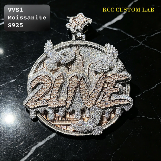 A custom round pendant featuring the word '2016' in large letters paved with rose gold and silver stones, flanked by two winged figures, set against a black marble background. Text overlays read 'VVS1 Moissanite S925' and 'RCC CUSTOM LAB'.