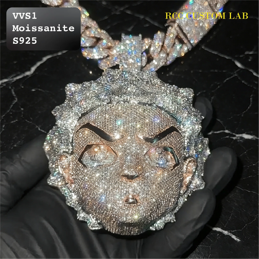 A heavily embellished face pendant covered in sparkling clear stones, held in a black gloved hand against a black marble background. Text overlays read 'VVS1 Moissanite S925' and 'RCC CUSTOM LAB'.