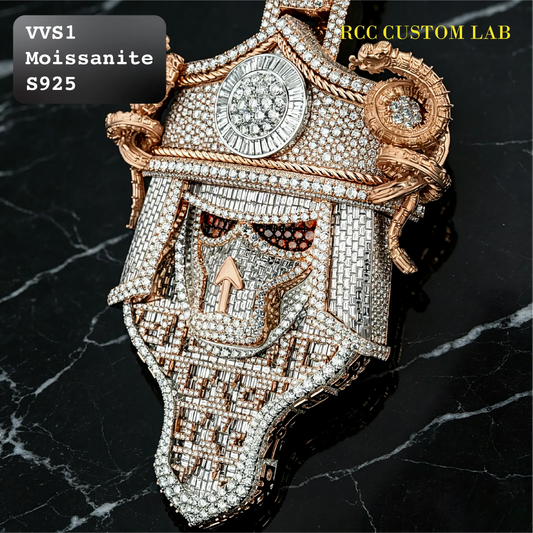 A heavily embellished skull-shaped pendant or brooch covered in clear stones, with rose-gold-toned metal outlines and decorative scrollwork. The piece is photographed on a black marble surface, with text overlays reading 'VVS1 Moissanite S925' and 'RCC CUSTOM LAB'.