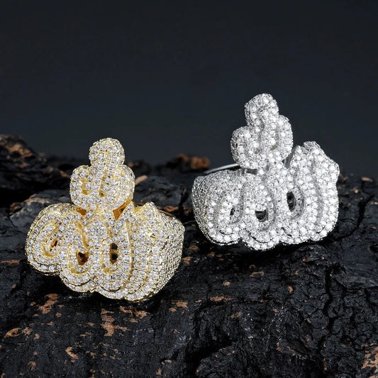 Gold and silver plated encrusted VVS moissanite Allah calligraphy ring pair, bold arabic symbol hip hop jewelry displayed on rough dark charred rock