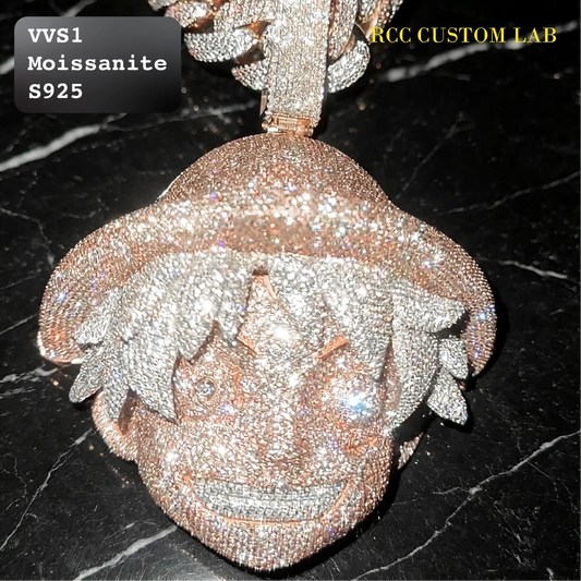 A close-up of a custom anime-style pendant featuring a character with spiky hair, heavily encrusted with clear stones in a rose gold setting, displayed on a black marble surface. Text overlays read 'VVS1 Moissanite S925' and 'RCC CUSTOM LAB'.