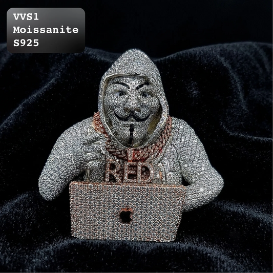 A hooded figure covered in sparkling silver stones, wearing a mask and sitting behind a laptop with the word "RED" on the front, displayed on a black velvet background. A black label in the top-left corner reads "VVS1 Moissanite S925".